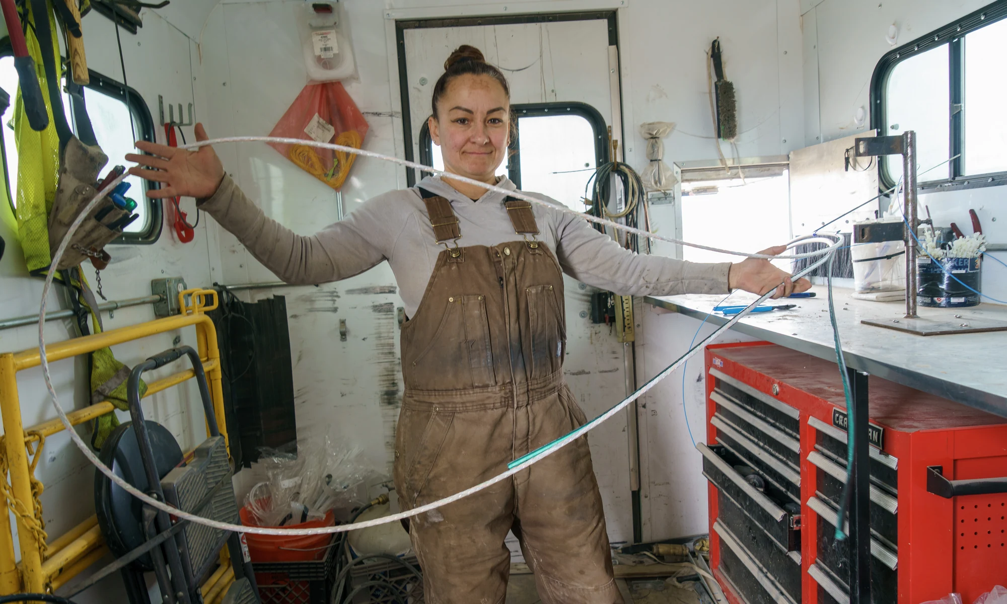 Fiber installation technician handling cable inside a field work trailer